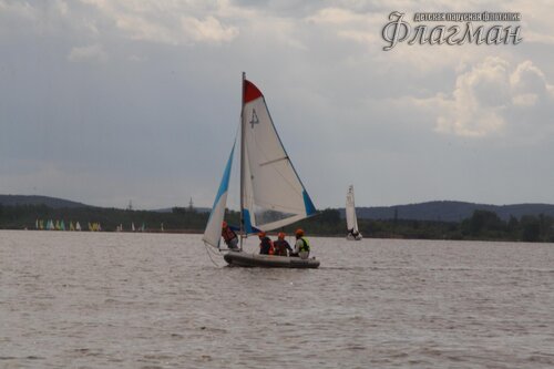 Яхта Вильсон на фоне берега и яхт